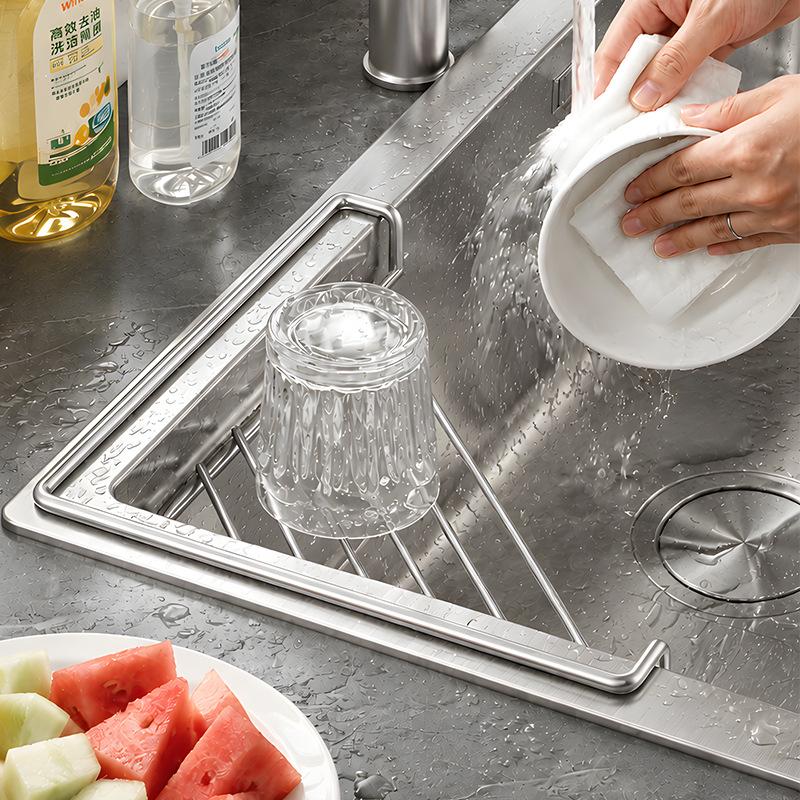 Glass draining on stainless steel corner shelf while dishes are being washed
